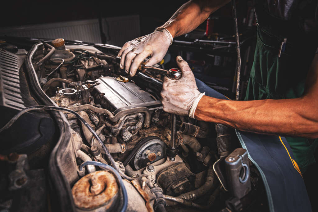 Hands of car mechanic in auto repair service